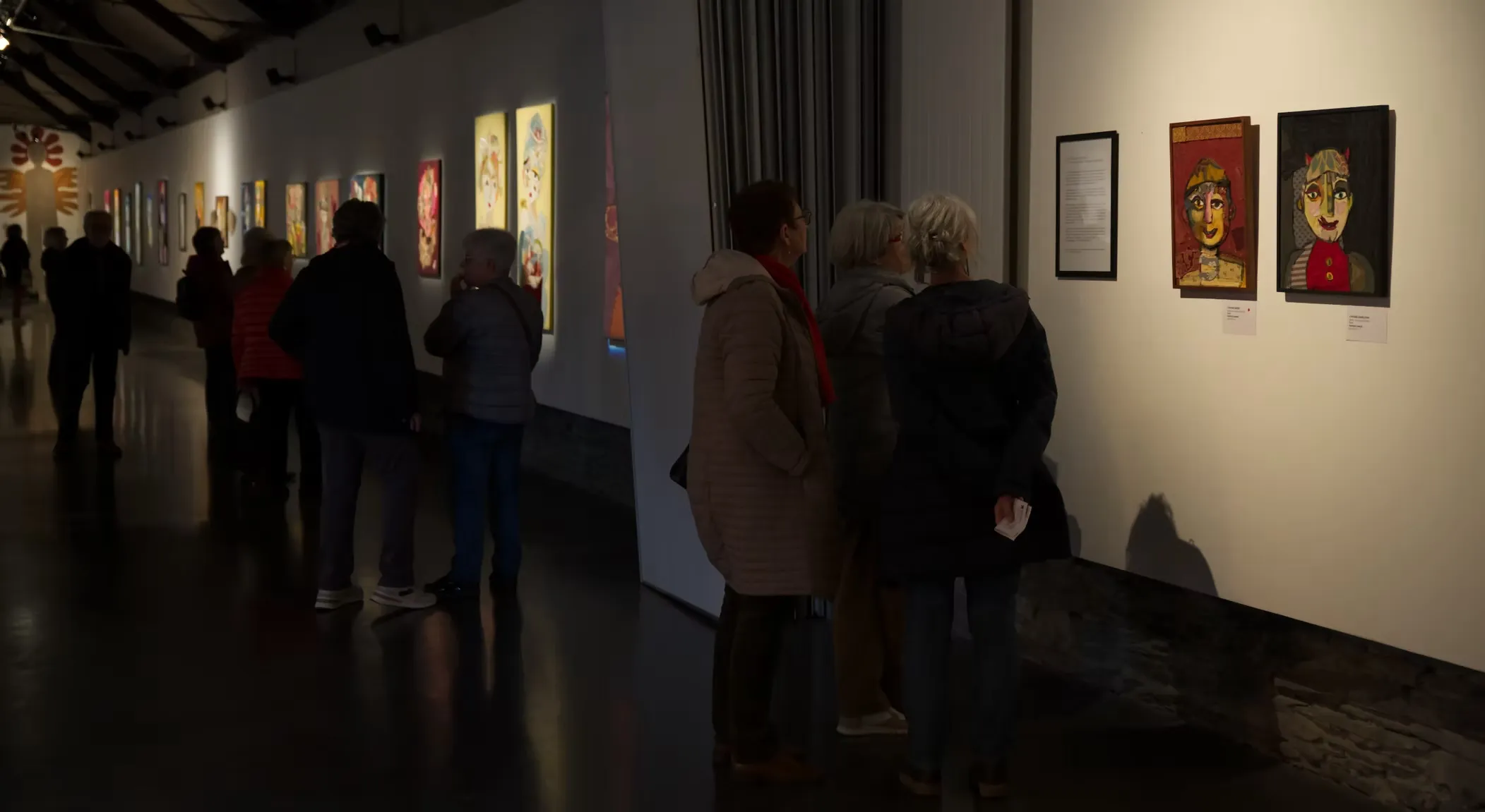 Salle d'exposition baignée de lumières colorées, portraits en tissu de l'artiste Katherine Roumanoff, Trélazé Angers France